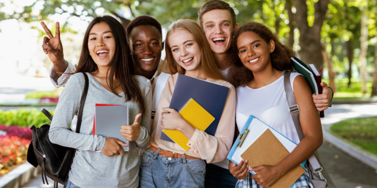 5 diverse students smiling with arms around each other