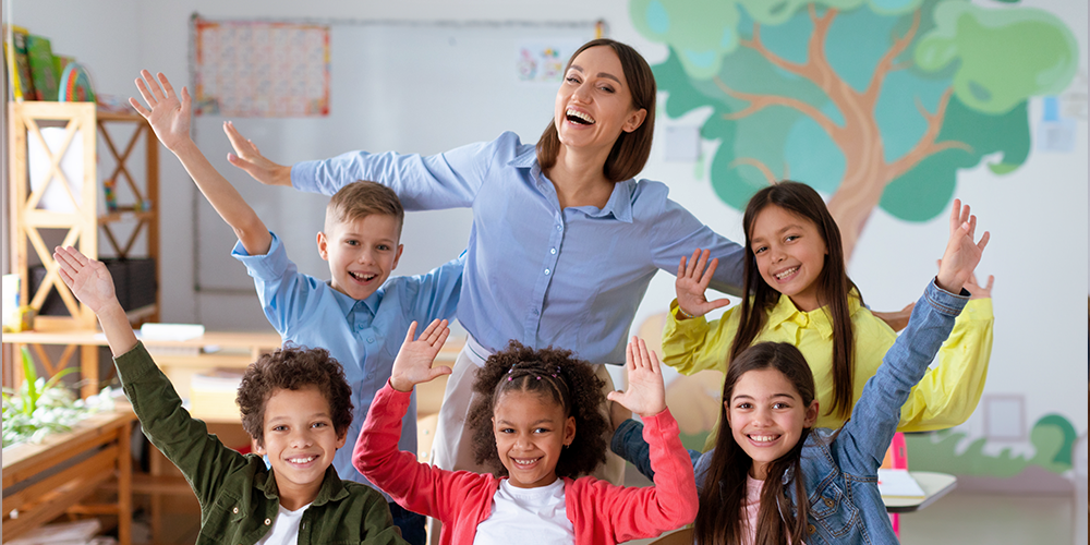 teacher smiling with students in classroom