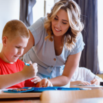 smiling teacher and student at desk